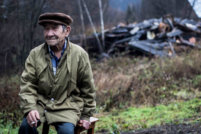 A villager in Kazas sitting by his burned out house. Credit RAIPON